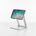 Adjustable silver aluminum phone and tablet stand on a clean desk